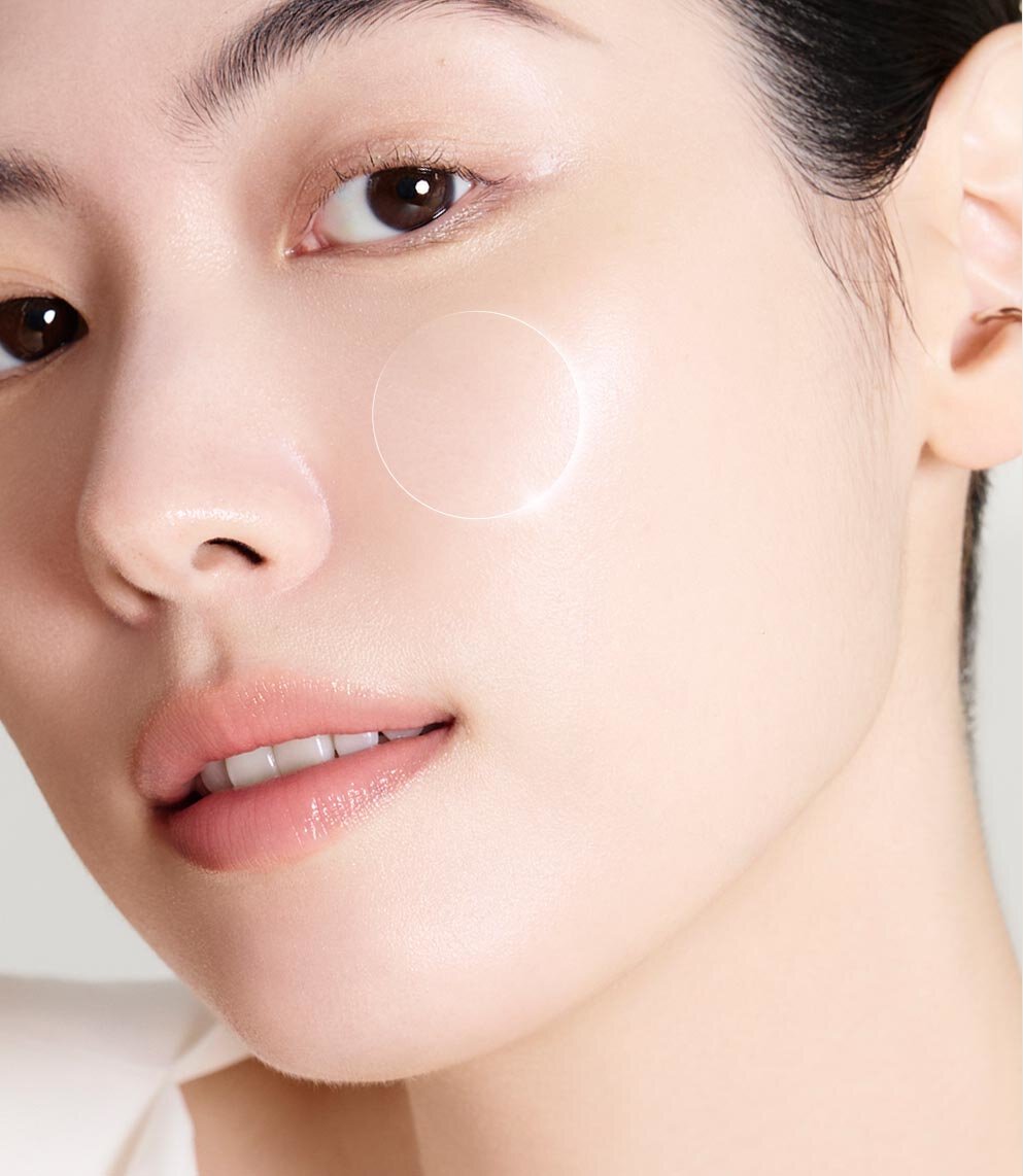 特寫畫面中呈現一位女性的面龐，臉頰上以高亮圓圈示意，展現雪花秀 Ultimate S Infusion Treatment 帶來的透亮水潤效果。