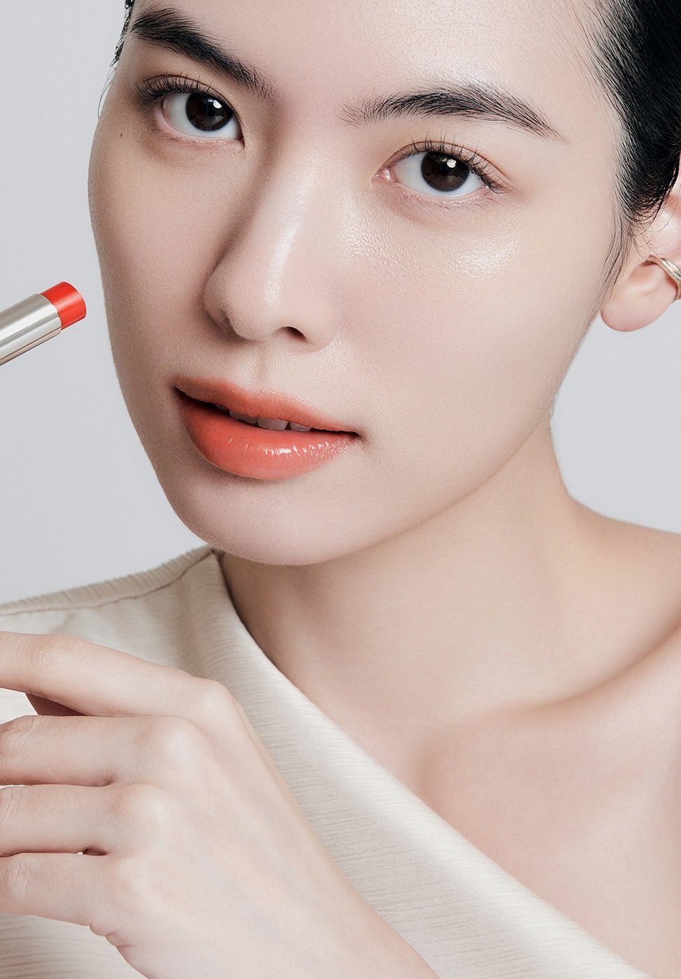 A model with Perfecting Lip Color NO.520 AMBER in hand
