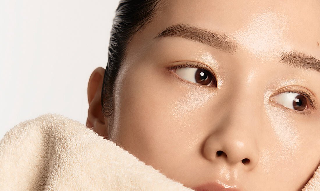Model wiping her face with a towel after washing her face
