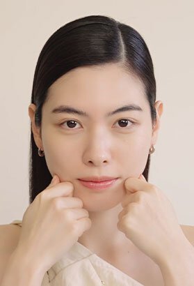 A woman gently lifts her cheeks, showcasing the lifting and firming effects of Sulwhasoo's Concentrated Ginseng Rejuvenating Cream, resulting in visibly radiant and youthful skin.
