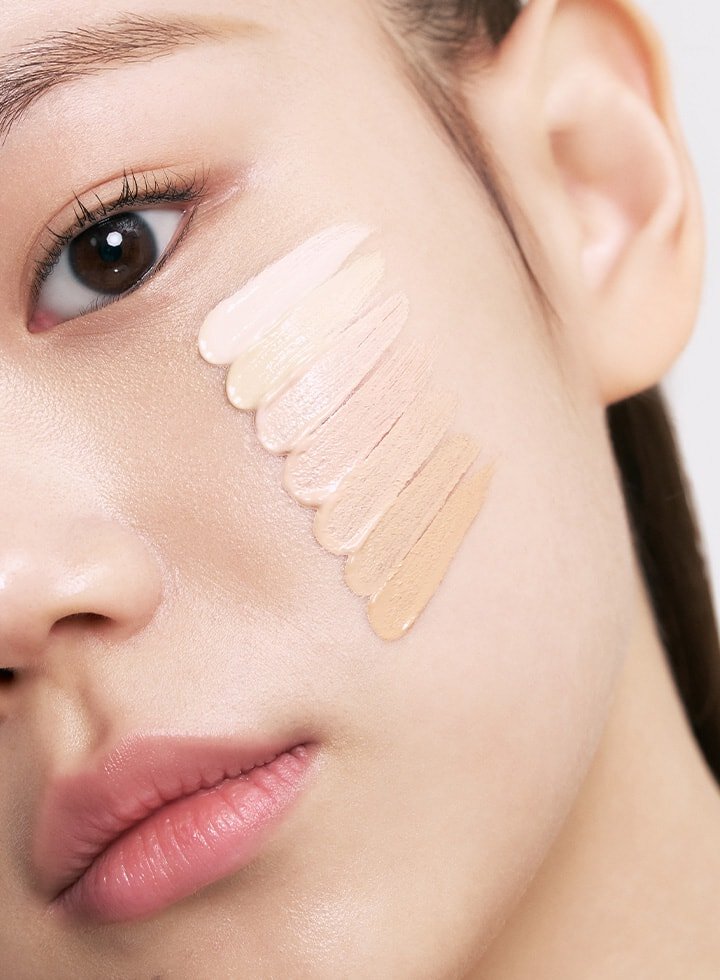 A woman's face displays swatches of Laneige NEO Cushion Mewy foundation shades, showcasing the various color options available.