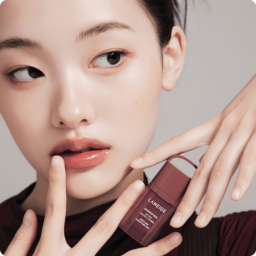 A woman holding Juicepop Box Lip Tint in the JAZZY JAM shade