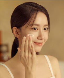 Yoona, with a gentle smile, applies Sulwhasoo's Concentrated Ginseng Rejuvenating Cream Rich, showcasing its creamy texture and highlighting the product's rejuvenating effect on her radiant, healthy-looking skin.
