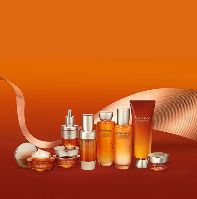 一組雪花秀人蔘活膚精華霜濃潤版及其他護膚品，在暖橘色背景中精心陳列，展現其奢華質地與琥珀色澤，承諾賦予肌膚活力與豐盈。