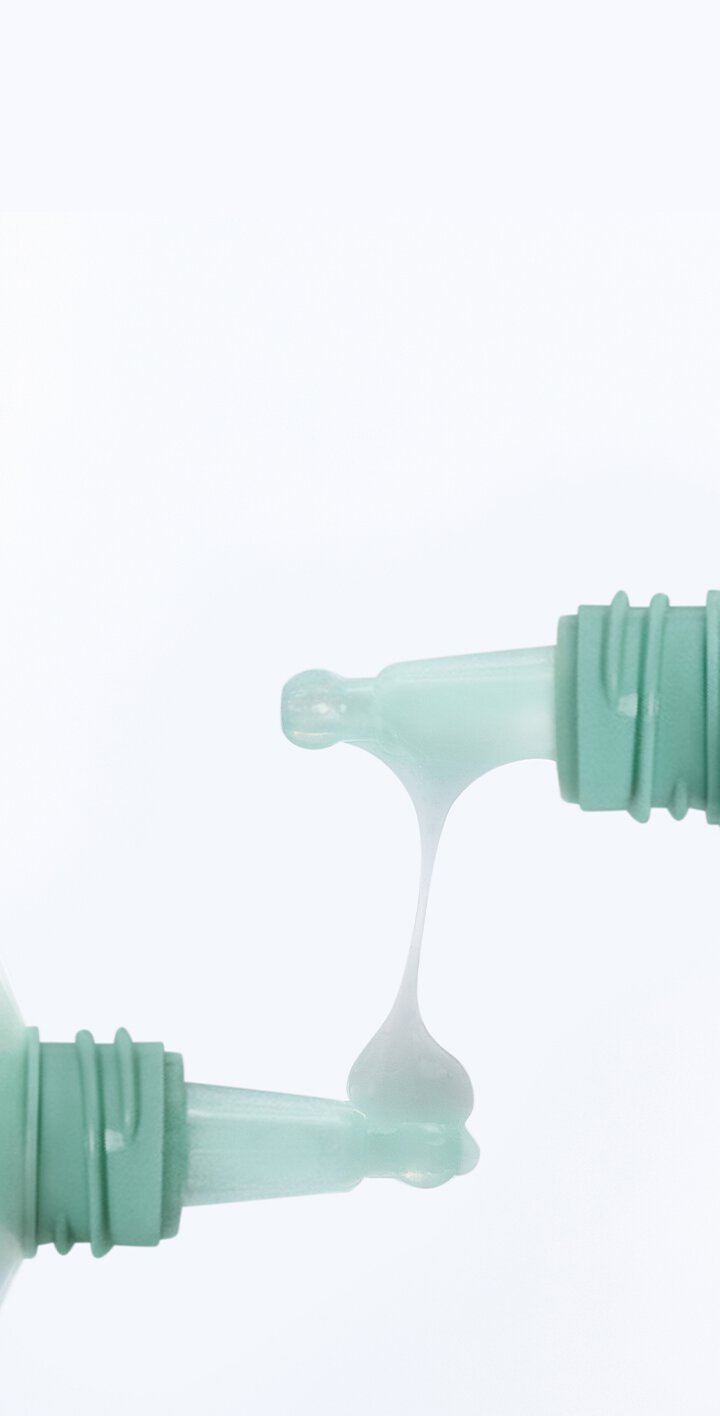 Close-up of the LANEIGE Smoothie Makeup Serum 30ml highlighting its silky, stringy texture between two mint-colored applicators.