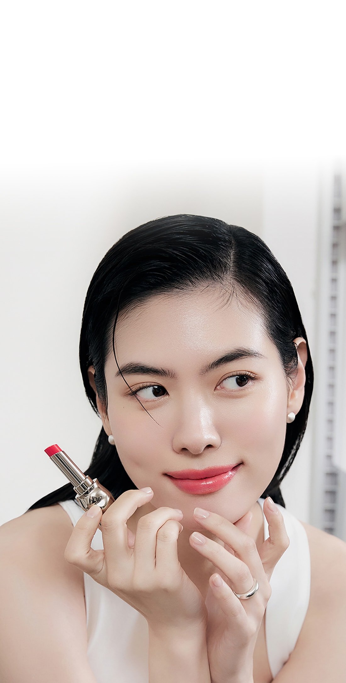 A model with Perfecting Lip Color NO.999 ROSE in hand