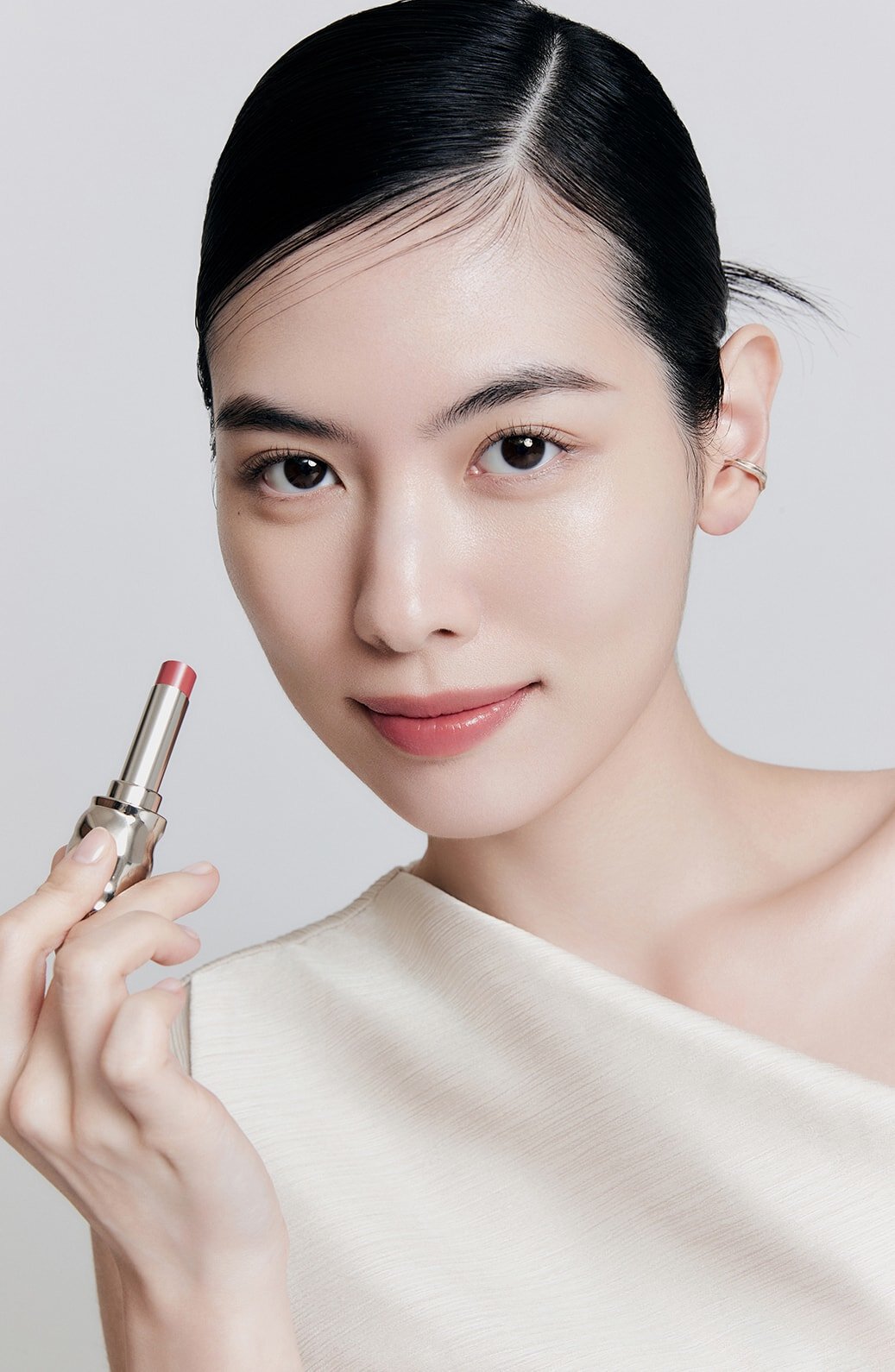 A model with Perfecting Lip Color NO.330 BLOOM in hand