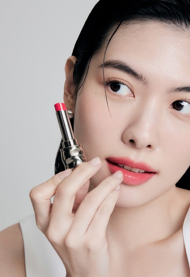 A model with Perfecting Lip Color NO.999 ROSE in hand