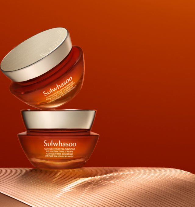 Two jars of Sulwhasoo Concentrated Ginseng Rejuvenating Cream Rich, one slightly elevated above the other, showcase the rich, amber color of the luxurious cream known for its rejuvenating properties.