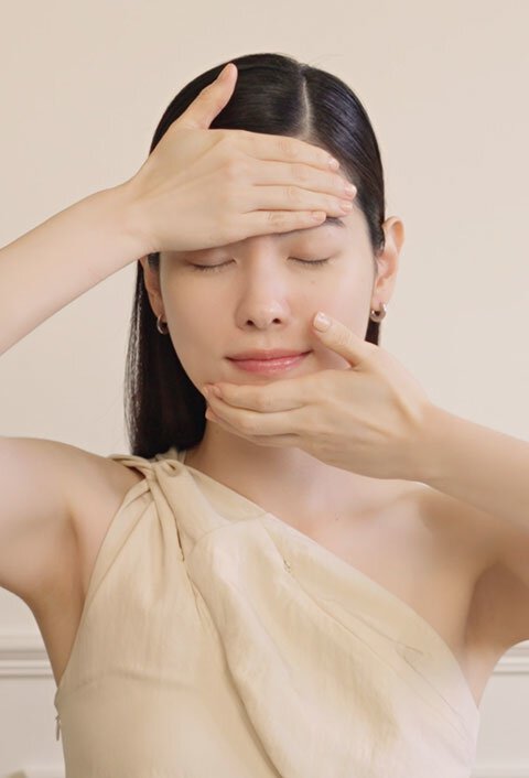 A woman gently massages the Sulwhasoo Concentrated Ginseng Rejuvenating Cream into her face, demonstrating its application for a more youthful and radiant complexion.