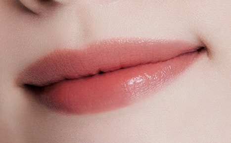 A model with Perfecting Lip Color NO. 330 BLOOM applied three times