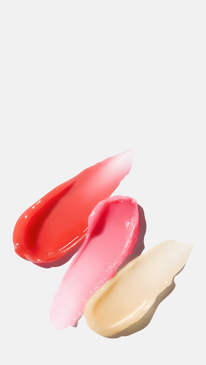 Swipes of Laneige's Lip Sleeping Mask in Strawberry Shortcake show its transformation from a pale yellow to a vibrant pink and finally a bold red, highlighting its moisturizing and color-enhancing properties.