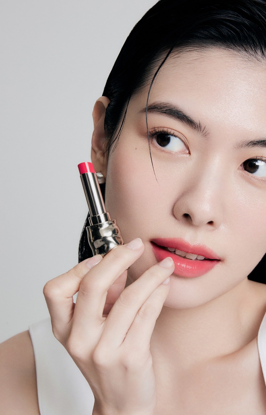 A model with Perfecting Lip Color NO.999 ROSE in hand