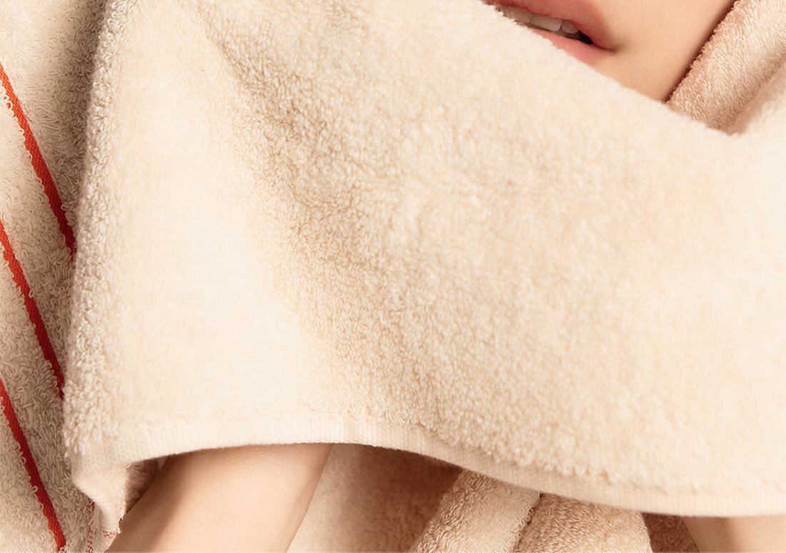 Model wiping her face with a towel after washing her face