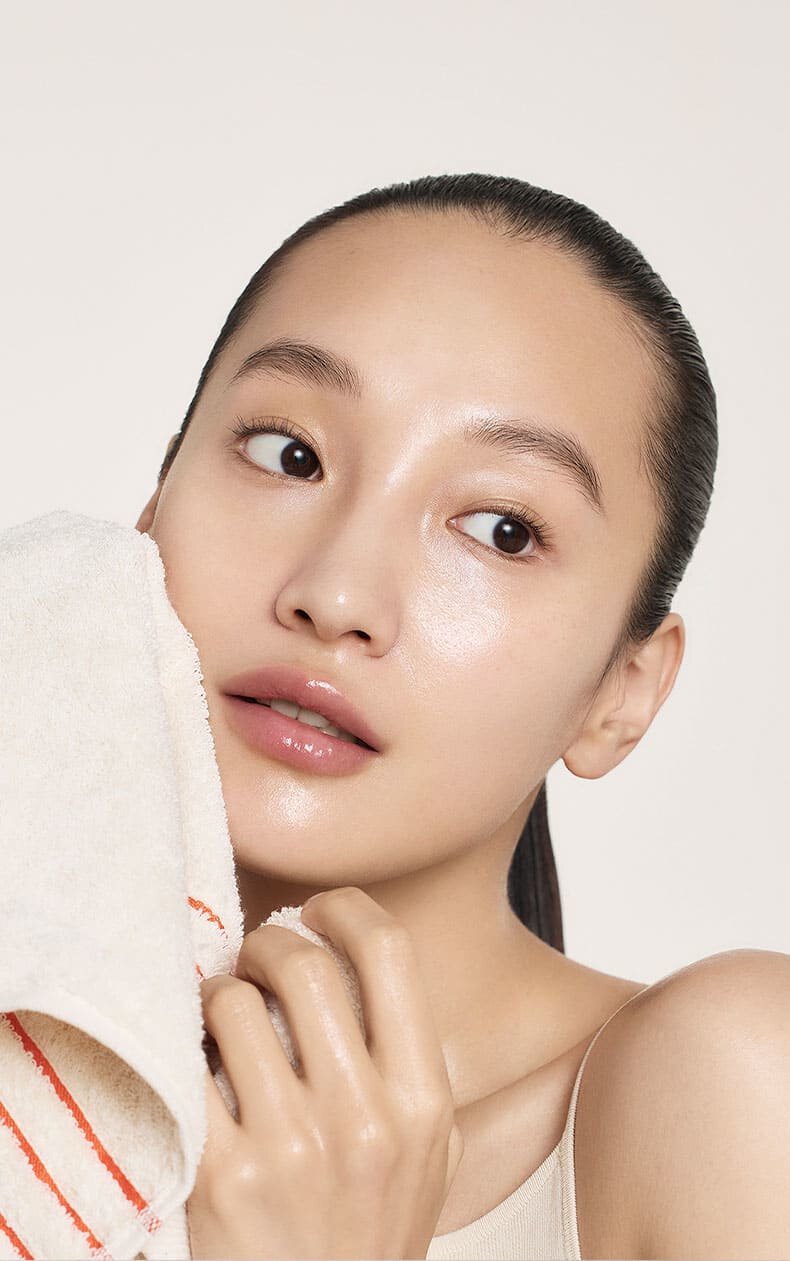 A model who wipes her face with a towel