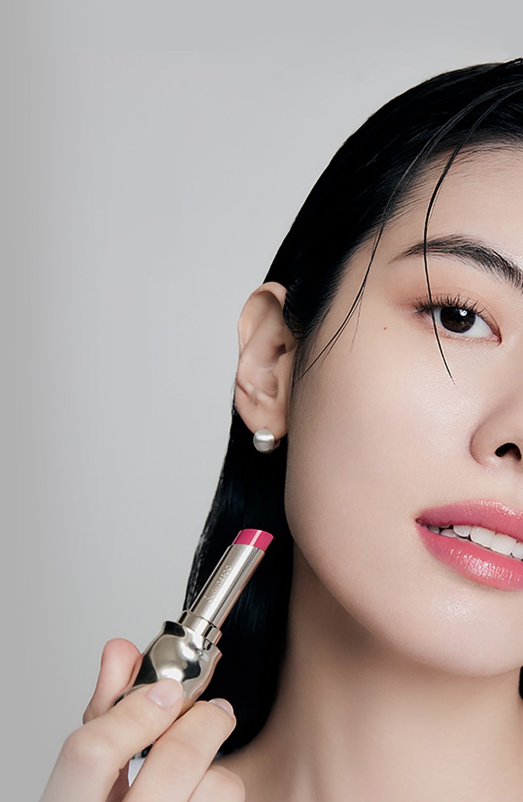 A model with Perfecting Lip Color NO.370 PEONY in hand