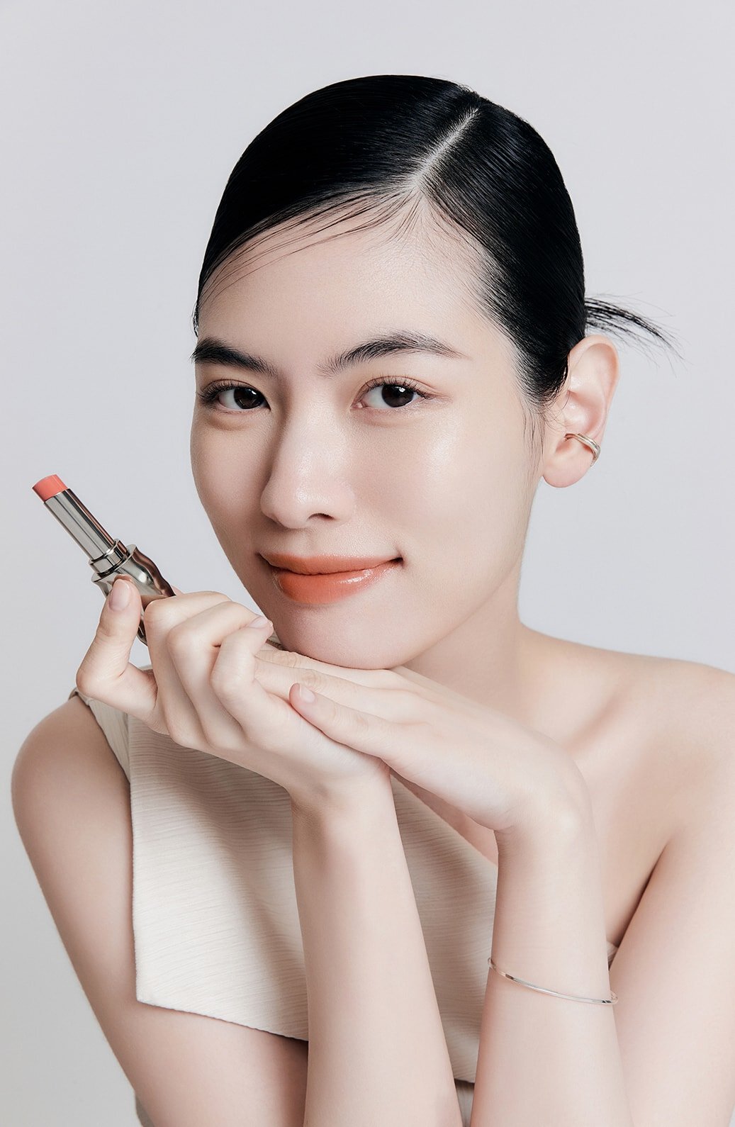 A model with Perfecting Lip Color NO.310 TERRA in hand