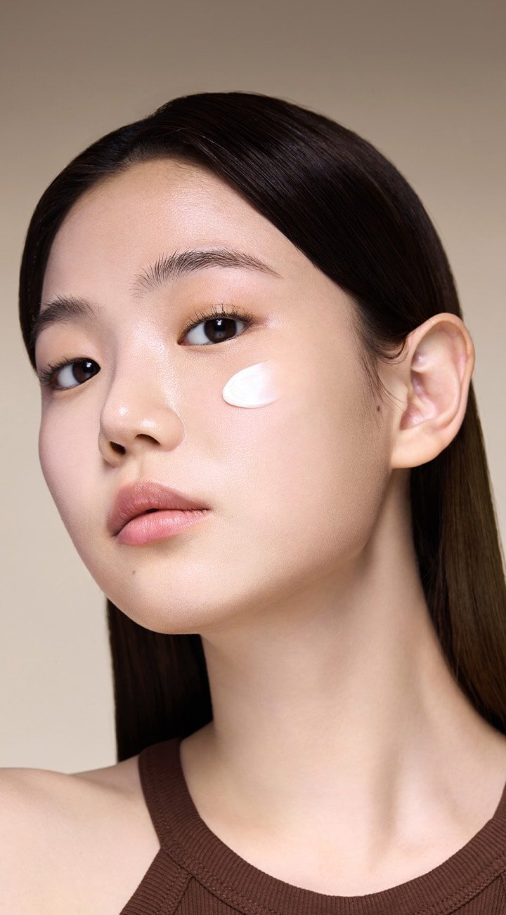 Model with Perfect Renew 3X Cream Advanced applied to cheek.